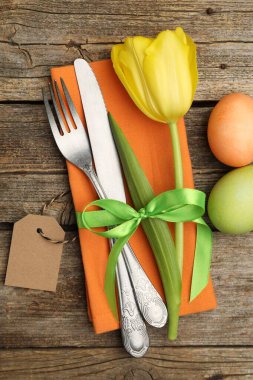 Paskalya sofrası. Lale ve ahşap arka planda boyanmış yumurtaları olan güzel gümüş takımlar.