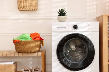 Çamaşır sepetinde çamaşır makinesinin yanında kirli çamaşırlar.