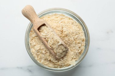 Kuru maya taneleri ve kepçeyle beyaz mermer masa, üst manzara.