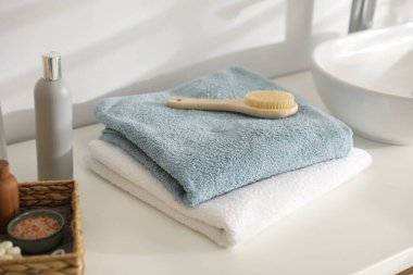 Banyodaki gösteriş üzerine temiz havlu ve kozmetik ürünleri yığını.