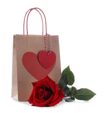 Kalbi olan bir hediye çantası ve bembeyaz bir gül. Sevgililer Günü
