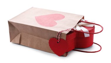 İçinde kalp şeklinde hediye paketi olan kağıt torba beyaza izole edilmiş. Sevgililer Günü