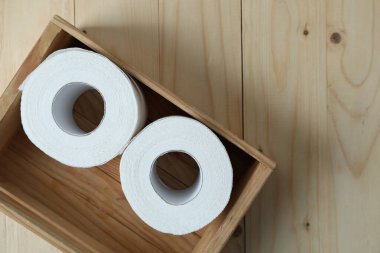 Tahta masadaki sandıkta tuvalet kağıdı ruloları, üst manzara. Metin için boşluk