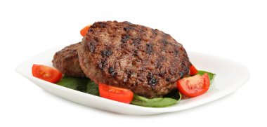 Lezzetli ızgara et köfteleri, domatesler ve beyaz üzerine izole edilmiş ıspanak.