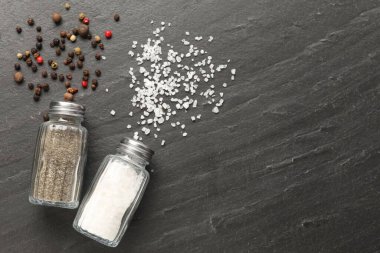 Siyah masada baharatlı tuzluk ve biberlik, düz. Metin için boşluk