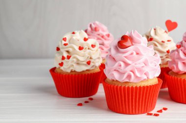 Sevgililer Günün kutlu olsun. Beyaz ahşap masada kalp şeklinde serpiştirilmiş lezzetli kek, yakın plan.