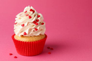 Sevgililer Günün kutlu olsun. Pembe arka planda kırmızı kalpleri olan lezzetli kek, yakın plan. Metin için boşluk