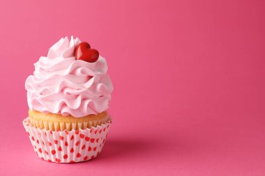 Sevgililer Günün kutlu olsun. Pembe arka planda kırmızı kalbi olan lezzetli bir kek, yakın plan. Metin için boşluk