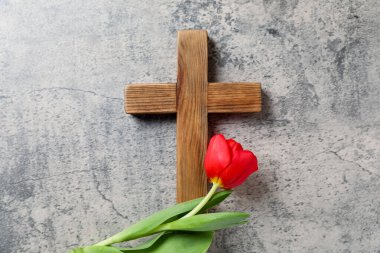 Paskalya özellikleri. Ahşap haç ve gri masada güzel lale, üst manzara.