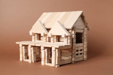 Kahverengi arka planda tahta bloklardan yapılmış ev