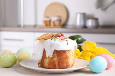 Lezzetli Paskalya pastası, boyanmış yumurta ve laleler mutfak masasında, yakın plan.