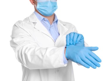 Doktor beyaz arka plana eldiven takıyor, yakın plan.