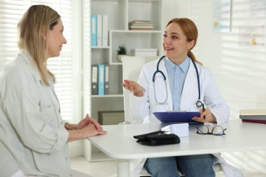 Gülümseyen kadın klinikteki masada kardiyologla randevusu var.