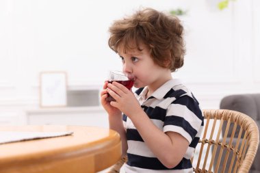 Küçük çocuk içeride, masada taze nar suyu içiyor. Metin için boşluk