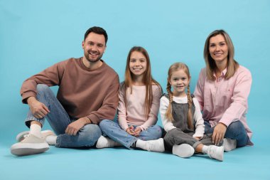 Açık mavi arka planda mutlu aile portresi