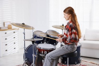 Davul çalmayı içeride öğrenen genç bir kız.