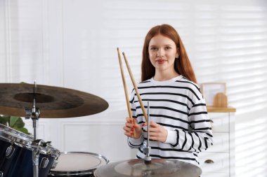 Davul çalmayı içeride öğrenen genç bir kız.