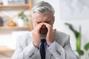 İş yorgunluğu. Ofiste acı çeken takım elbiseli işadamı.