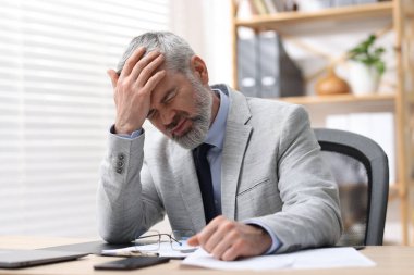 İş yorgunluğu. Masada acı çeken takım elbiseli işadamı.