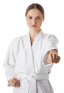 Üniformalı kadın beyaz arka planda karate yapıyor.