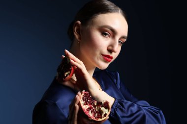 Mavi arka planda olgun narı olan güzel kadın.