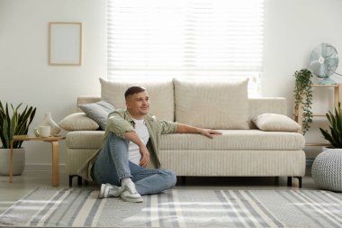 Evdeki kanepenin yanında dinlenen genç adam, mesaj için yer var.