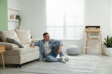 Evdeki kanepenin yanında dinlenen genç adam, mesaj için yer var.