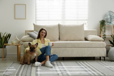 Şirin köpeği ve bir bardak içkisi olan bir kadın evinde kanepenin yanında dinleniyor, mesaj atmak için yer var.