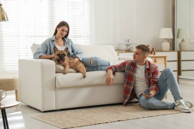 Evde dinlenen sevimli köpekli bir çift.