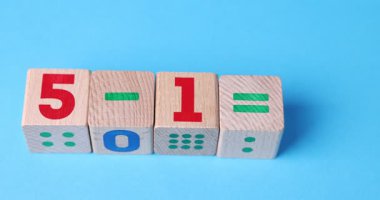 Hafif arkaplanda tahta küplerle yapılan matematiksel işlemleri çözen kadın, yakın plan