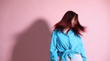 Pembe arka planda renkli saçlı bir kadın.