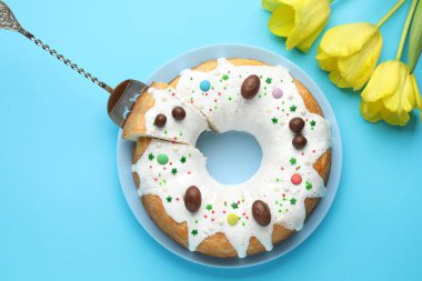 Lezzetli Paskalya pastası ve açık mavi arka planda sarı laleler.