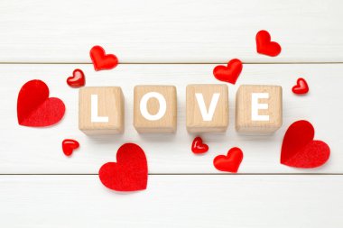 Tahta küplerde aşk ve kırmızı kalpler beyaz masada, düz yerde. Tebrik kartı