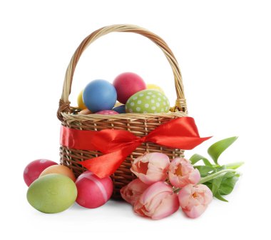 Paskalya sepeti boyalı yumurtalar ve beyaz üzerinde izole edilmiş güzel laleler.
