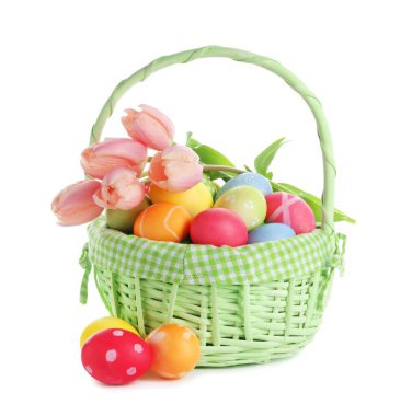 Paskalya sepeti boyalı yumurtalar ve beyaz üzerinde izole edilmiş güzel laleler.