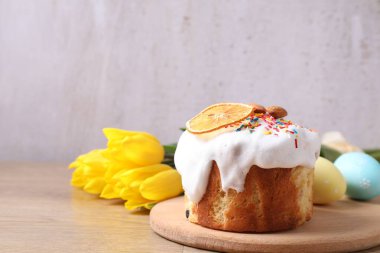 Lezzetli Paskalya pastası, laleler ve boyanmış yumurtalar gri arka planda. Metin için boşluk