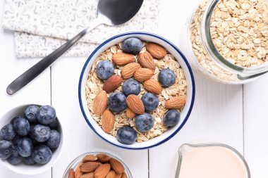 Yulaf gevreği, badem sütü, yaban mersini ve fındık beyaz ahşap masa, düz yatıyordu.