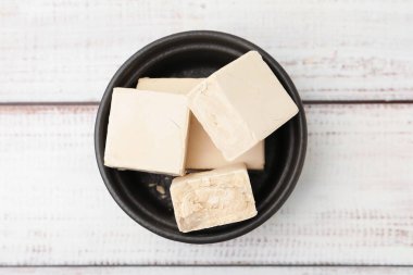 Tabaktaki taze maya parçaları açık ahşap masa, üst manzara.