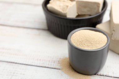 Kasede kurutulmuş maya ve açık ahşap masada taze olanlar, yakın plan. Metin için boşluk