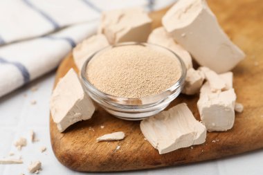 Beyaz fayanslı masada taze ve kuru maya, yakın plan.