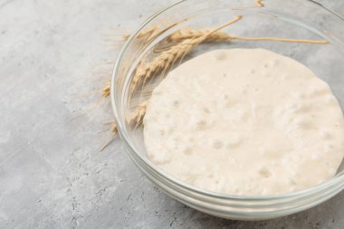 Cam kasede taze maya hamuru ve gri masada çiviler, yakın plan. Metin için boşluk