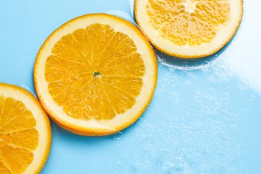 Açık mavi zemin üzerinde portakal dilimleri, düz bir zemin. Metin için boşluk