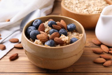 Bademli yulaf ezmesi ve ahşap masada yaban mersini, yakın plan.