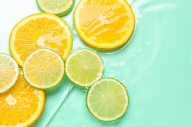 Turkuaz arka planda sudaki turunçgil meyveleri, düzlük. Metin için boşluk