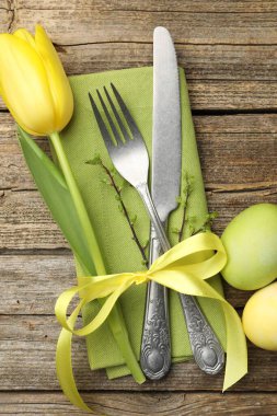 Paskalya sofrası. Lale ve ahşap arka planda boyanmış yumurtaları olan güzel gümüş takımlar.