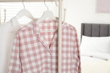 İçerideki yatağın yanındaki askıda asılı şık pijama gömlekler, yakın plan. Metin için boşluk