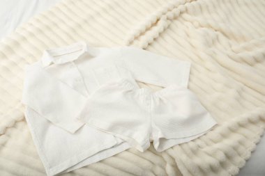 İçerideki yatağın üstünde şık pijamalar.