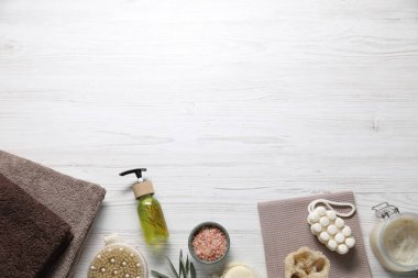 Temiz havlular ve kozmetik ürünleri açık ahşap masada, düz yerde. Metin için boşluk