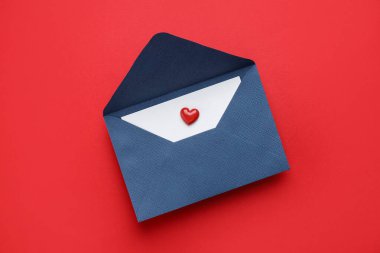 Sevgililer Günün kutlu olsun. Tebrik kartı ve kırmızı arka planda dekoratif kalp ile zarf, üst görünüm