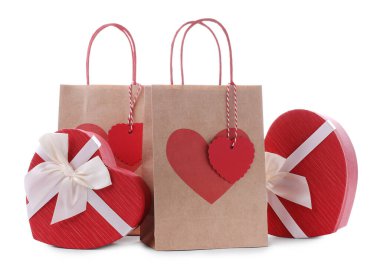 İçinde kalp şeklinde hediye paketleri olan kağıt torbalar beyaza izole edilmiş. Sevgililer Günü